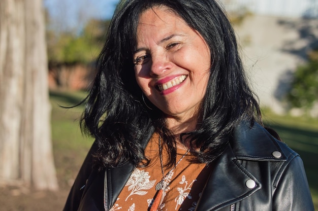 Retrato linda mulher latina adulta ao ar livre sorrindo olhando para a câmera