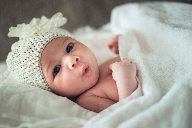 Foto retrato de una linda niña acostada en la cama