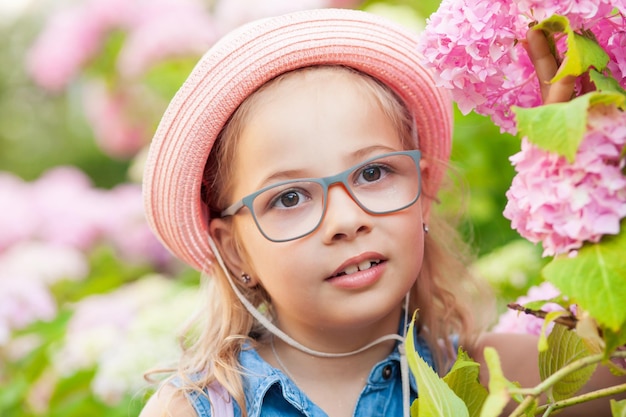 Retrato de una linda niña con anteojos y vestido.