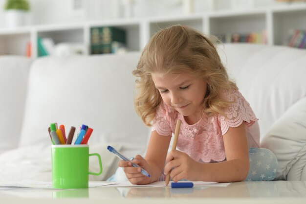 Retrato de una linda niña dibujando con marcadores