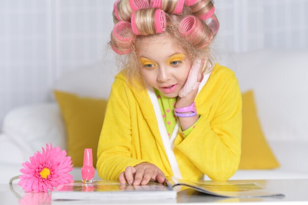 Retrato de una linda niña leyendo una revista