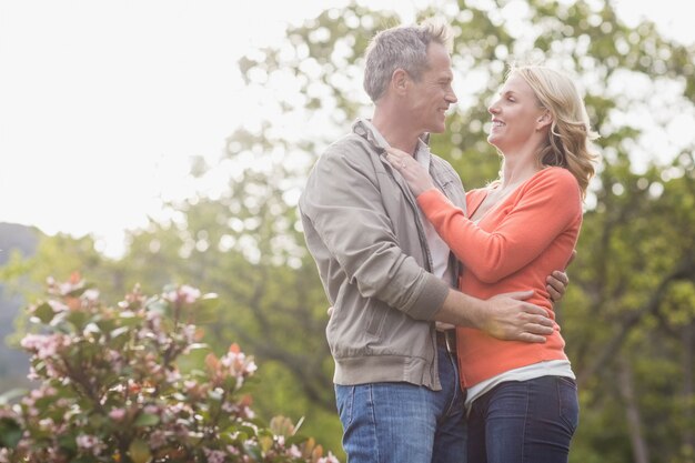 Retrato de linda pareja abrazándose en el jardín