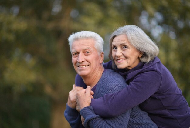 Retrato de una linda pareja de ancianos en el parque de otoño