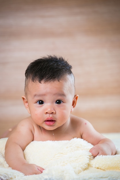 Retrato lindo bebé asiático en la habitación de la cama