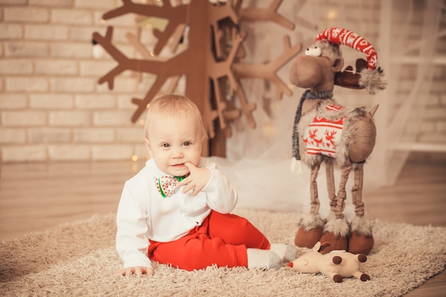 Retrato de lindo bebé niño entre adornos navideños