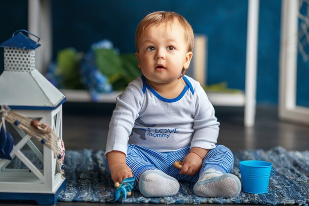 Retrato de un lindo bebé niño en el interior con estilo mar