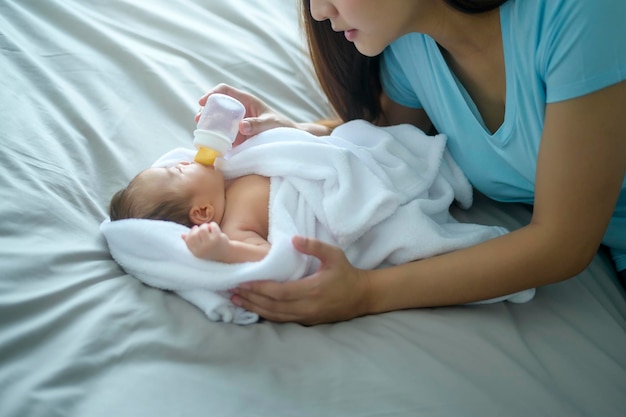 Retrato de un lindo bebé recién nacido bebiendo una botella de leche