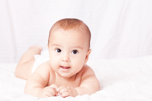 Retrato de un lindo bebé sonriente que muestra la primera leche o dientes temporales