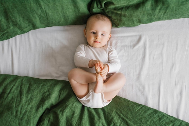 Retrato de un lindo y encantador niño blanco caucásico riéndose sonriente de seis meses acostado en una cama y mirando a la cámara Vista desde arriba Un estilo de vida feliz en la infancia