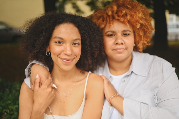 Retrato lindo lindo casal afro-americano de lésbicas se abraçando na cidade