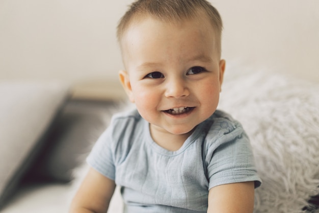 Retrato de un lindo niño en un dormitorio