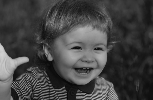 Retrato de lindo niño emocionado divirtiéndose en el jardín cara de bebé cerca divertido pequeño puerto de primer plano de niño