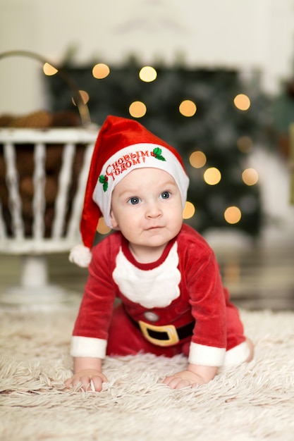 Retrato de un lindo niño jugando en el piso con conos para decorar el árbol de Navidad. Cerca del árbol de Navidad y cajas con regalos de Navidad.