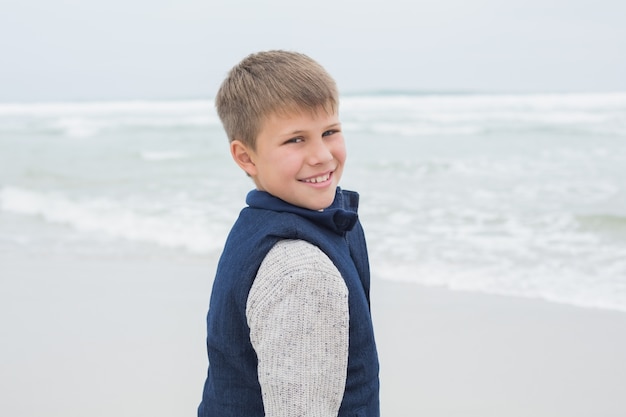 Retrato de un lindo niño sonriente en la playa