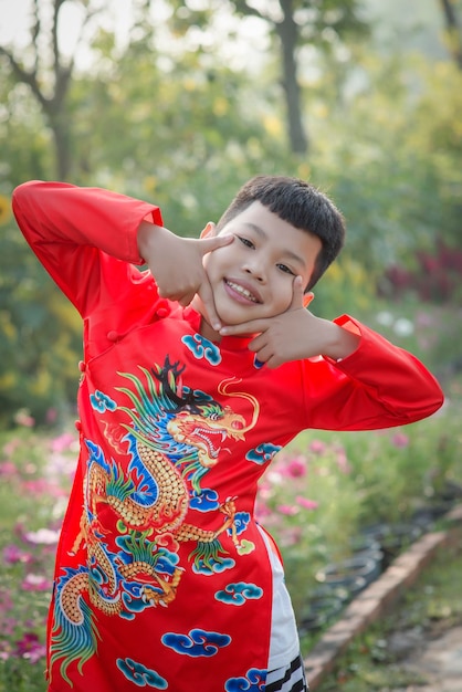 Retrato de un lindo niño sonriente con ropa tradicional mientras está de pie al aire libre