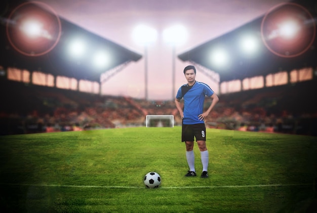 Retrato de longitud completa de un jugador de fútbol de pie en el estadio