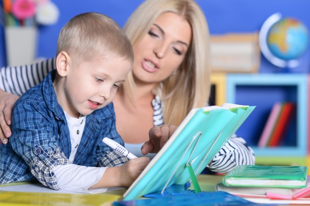 Retrato de una madre ayudando a su hijo con lecciones