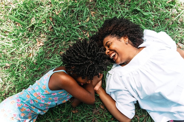 Retrato, de, madre e hija, acostado, en, el, pasto o césped, feliz y sonriente