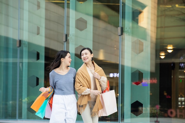 Retrato, de, un, madre e hija, ambulante, con, bolsas de compras