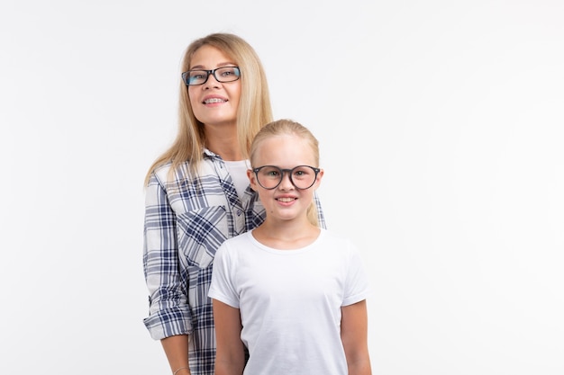 Retrato de madre e hija con anteojos sobre fondo blanco.