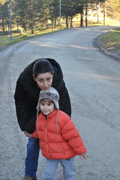 Foto retrato de madre e hija en la carretera contra los árboles