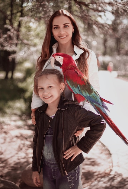 Retrato de madre e hija con loro guacamayo