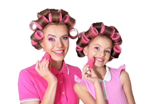 Retrato de madre e hija pequeña en rulos para el cabello