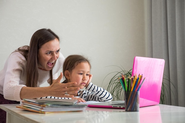 Foto retrato de madre e hija sentadas en la mesa