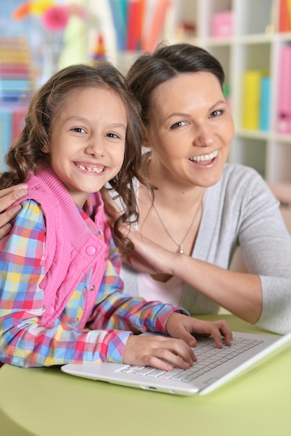 retrato, de, madre e hija, usar la computadora portátil