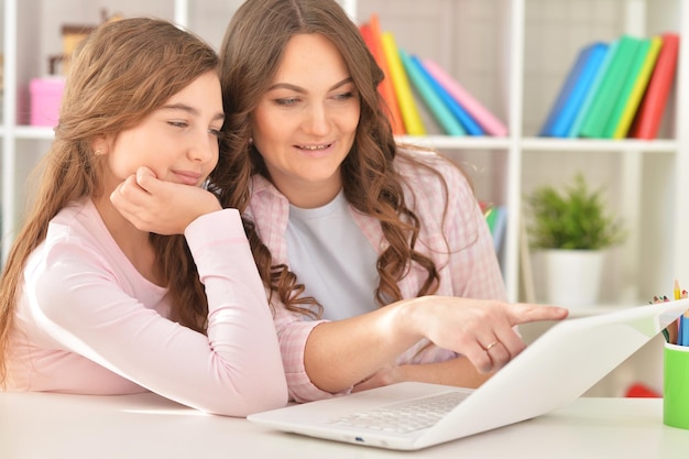 Foto retrato, de, un, madre e hija, usar la computadora portátil