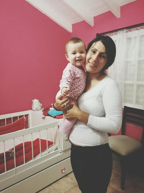 Foto retrato de una madre feliz con su hija de pie en casa