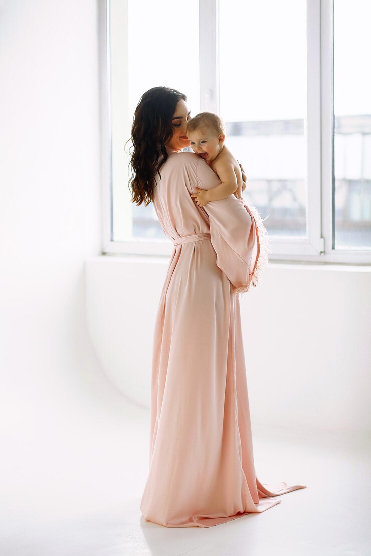 Foto retrato de una madre con una hermosa bata de ping sosteniendo a su niña día de la madre