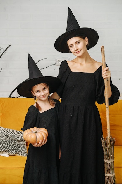 Retrato de una madre y una hija con disfraces de brujas para halloween