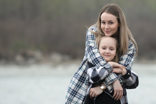 retrato de madre con hija en el fondo de la naturaleza junto al río