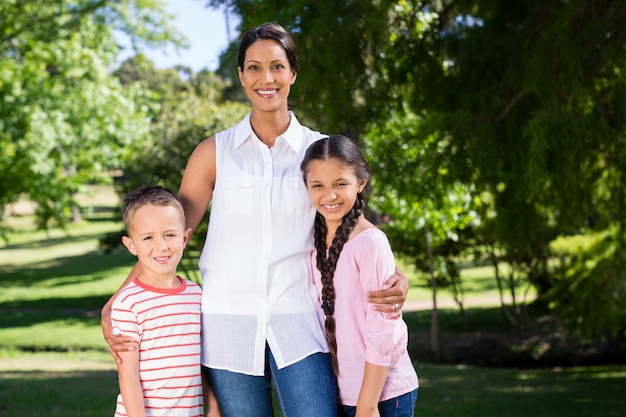 Retrato de la madre de pie con sus hijos en el parque