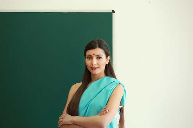 Retrato de una maestra india cerca de la pizarra en el aula