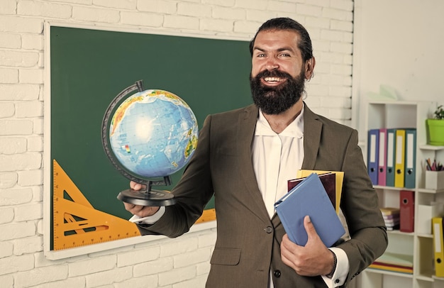 Foto retrato de un maestro de escuela en un aula académica con geografía mundial