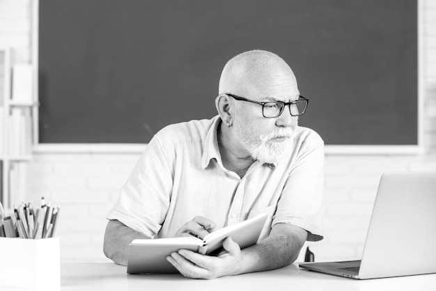 Retrato de un maestro senior caucásico confiado en el aula de aprendizaje de adultos profesor de mediana edad