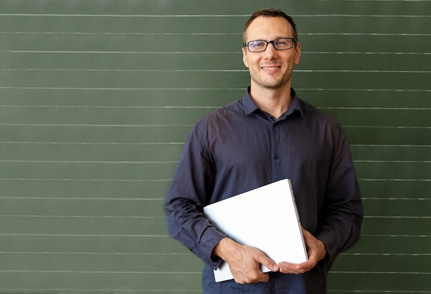 Foto retrato de un maestro usando una tableta digital cerca de la junta escolar