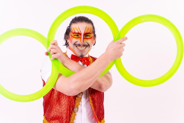 Retrato de un malabarista sonriendo con aros de malabarismo aislado sobre fondo blanco.