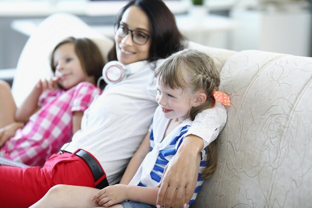 Retrato de mamá morena feliz pasando tiempo con niños sonriendo abrazando a su hija en