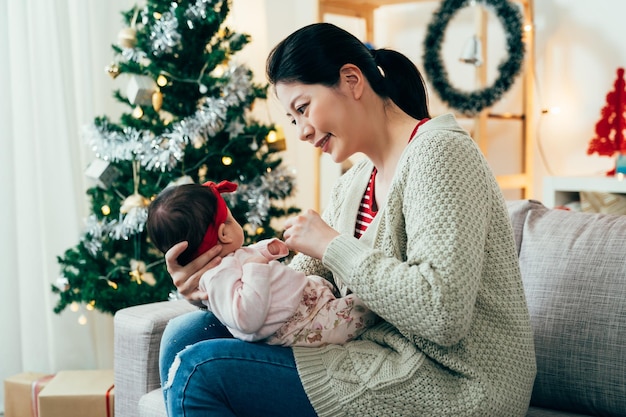 retrato mamá primeriza taiwanesa está mirando a su bebé con amor. hermosa mujer asiática interactuando con su hijo con alegría. estilo de vida autentico