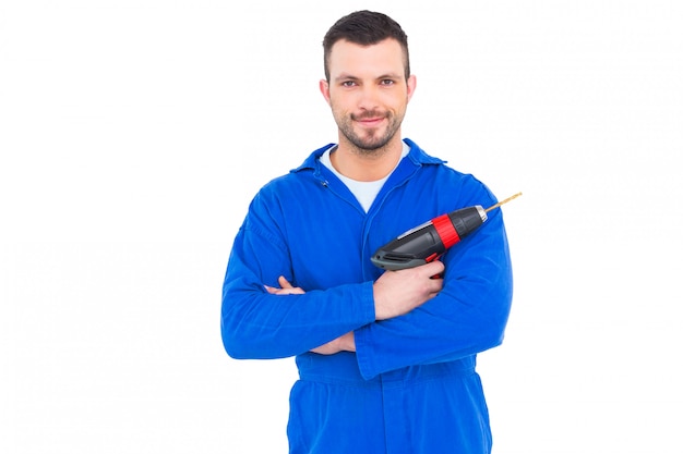 Retrato de la manitas confiada que sostiene el taladro de potencia en el fondo blanco