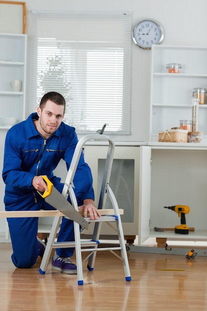 Retrato de un manitas cortando una tabla de madera