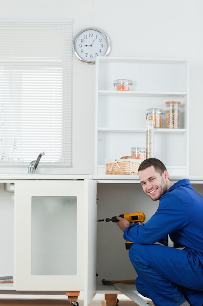 Foto retrato de un manitas sonriente arreglando una puerta