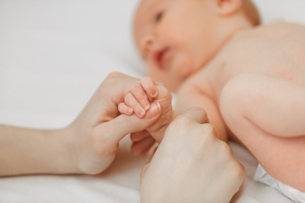 Retrato de la mano de los niños recién nacidos en la mano de la madre.