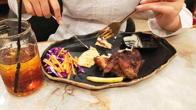 retrato de manos de mujeres arreglando pan de pita khubus acompañado de pollo asado en el horno típico de Ara