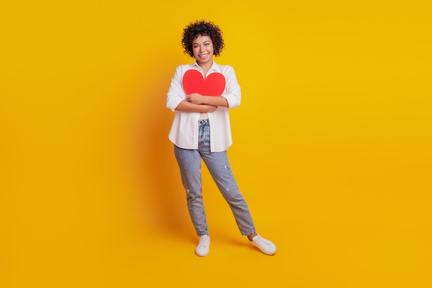 Retrato de manos de niña abrazan concepto de amor de figura de corazón de papel rojo