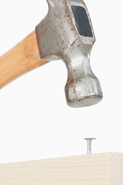 Foto retrato de un martillo manejando un clavo