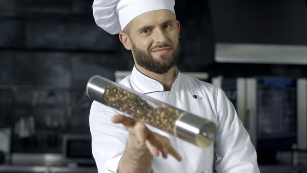 Retrato masculino de chef en restaurante de cocina Chef masculino jugando con pepperbox